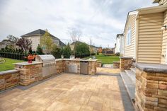 an outdoor kitchen and grill area in a backyard