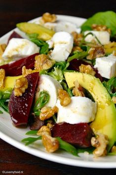 a white plate topped with beets, feta cheese and walnuts