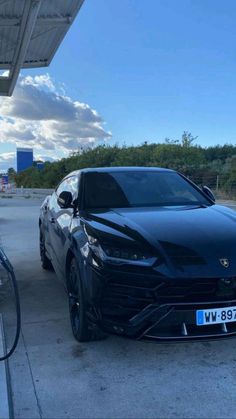 a black sports car parked at a gas station