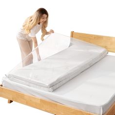 a woman is placing sheets on top of a bed frame to protect it from the sun