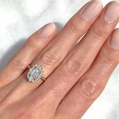 a woman's hand with a diamond ring on her finger and an engagement band