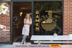 a woman standing in the doorway of a ramen restaurant