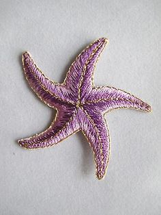 an embroidered purple starfish on a white background