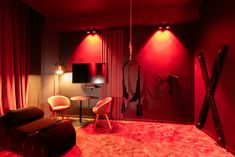 a room with red lighting and two chairs