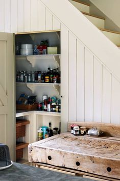 a wooden bed sitting under a stair case