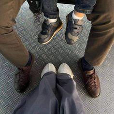 two people standing next to each other with their feet on the ground and one person wearing brown shoes