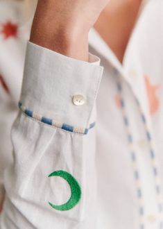 a close up of a person wearing a white shirt with a green crescent on it