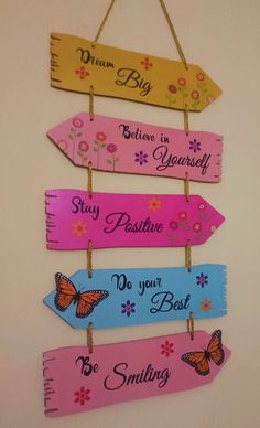 four wooden signs hanging on a wall with butterflies and flowers painted on them that say, believe in yourself stay positive do your best