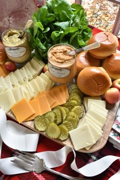 an assortment of cheeses, pickles, and other foods on a platter