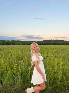 a woman standing in the middle of a field