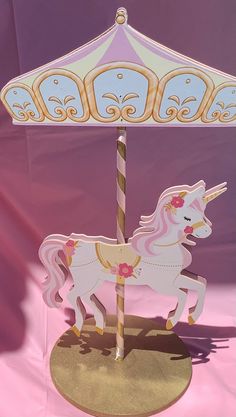 a pink and white carousel horse with flowers on it's head, standing in front of a purple background