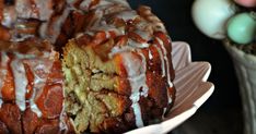 a bundt cake with white icing on a plate next to an easter egg