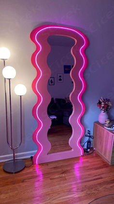 a mirror that is sitting on top of a wooden floor in front of a lamp