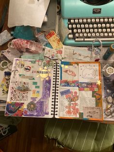 an old fashioned blue typewriter sitting on top of a table next to a pile of papers