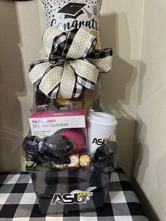 a gift basket is sitting on top of a black and white checkered tablecloth