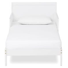 a white bed with two pillows on top of it and a pillow in the middle