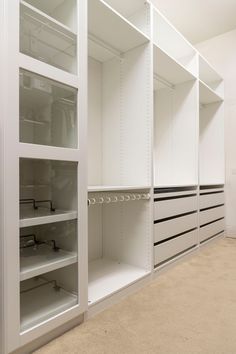 an empty walk in closet with white shelves