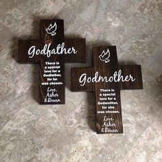 three wooden crosses with the names of different people on them sitting on a marble surface