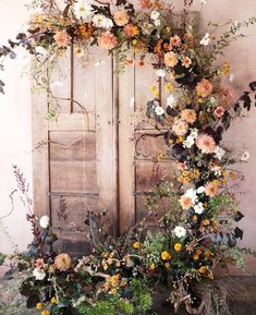 an old wooden door with flowers growing out of it