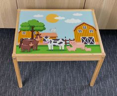 a wooden table with farm animals painted on it