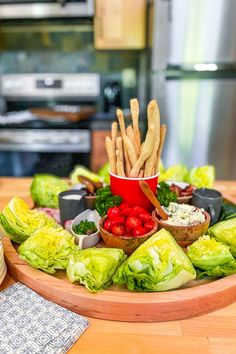 a wooden plate topped with lettuce and other foods