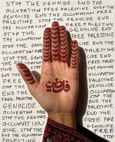 a person's hand with the word written in arabic on it and their fingers painted red