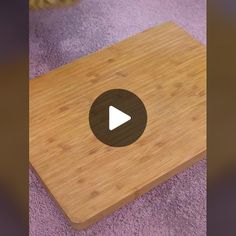 a wooden cutting board sitting on top of a purple rug