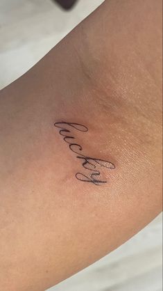 a woman's arm with the word love written in cursive writing on it