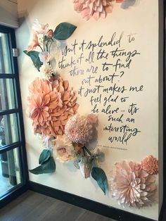 the wall is decorated with paper flowers and an old poem written on it in cursive writing