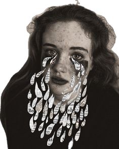 a woman with her face covered in fake nails and feathers on her head, looking at the camera