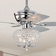 a ceiling fan with crystal balls hanging from it's blades in a living room