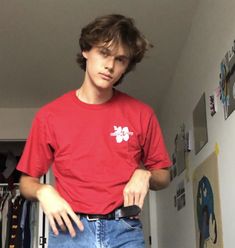 a young man standing in front of a closet