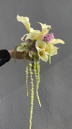 a person holding a bouquet of flowers in their hand