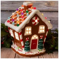 a lighted gingerbread house with candy on the roof