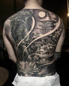 the back of a man's body with tattoos on it