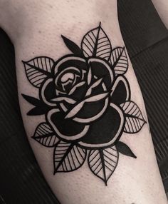 a black and white rose tattoo on the leg