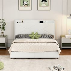 a white bed sitting in a bedroom next to two pictures on the wall above it