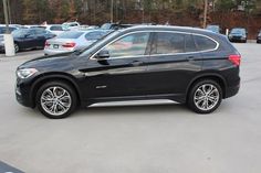 a black bmw suv parked in a parking lot