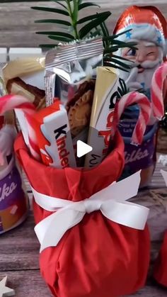 a bag filled with candy and candies sitting on top of a wooden table next to a potted plant