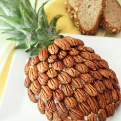 there is a pineapple made out of nuts on the white plate next to it