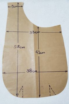 a piece of brown paper with measurements for the top and bottom half of it, on a white surface