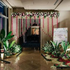 an entrance decorated with pink flowers and greenery for a wedding or special event venue