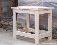 a small wooden table sitting in front of a wall