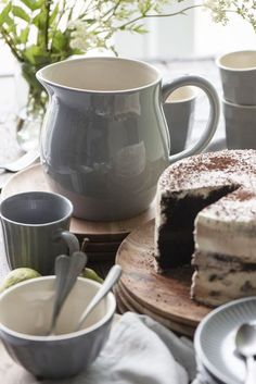 a table topped with plates and cups filled with cake