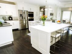 a large kitchen with white cabinets and stainless steel appliances