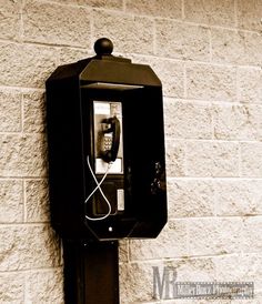 an old fashioned phone is attached to a brick wall