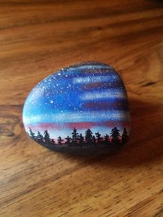 a painted rock sitting on top of a wooden table