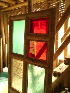 the inside of a bamboo house with several different colored glass panels on it's walls