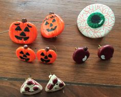 several pumpkins, apples, and donuts are sitting on a wooden table together