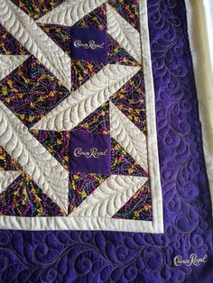 a purple and white quilted table runner with the words royal written in gold on it